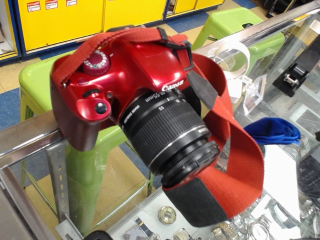 Camera canon rouge avec lentille et stra